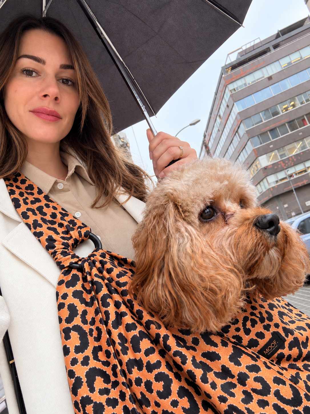 Audrey avec Milo dans un sac de portage léopard MOOF., sous un parapluie en ville